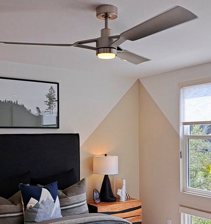 A modern ceiling fan with light installed in a bedroom
