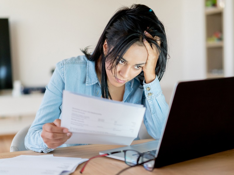 A frustrated homeowner reviewing her HOA's CC&R's and budget