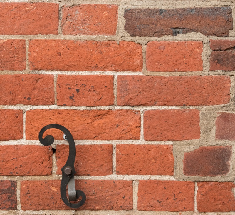Old brick wall of a colonial home with several eras of patchwork