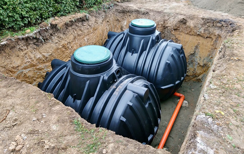 Two large rainwater storage tanks being installed underground