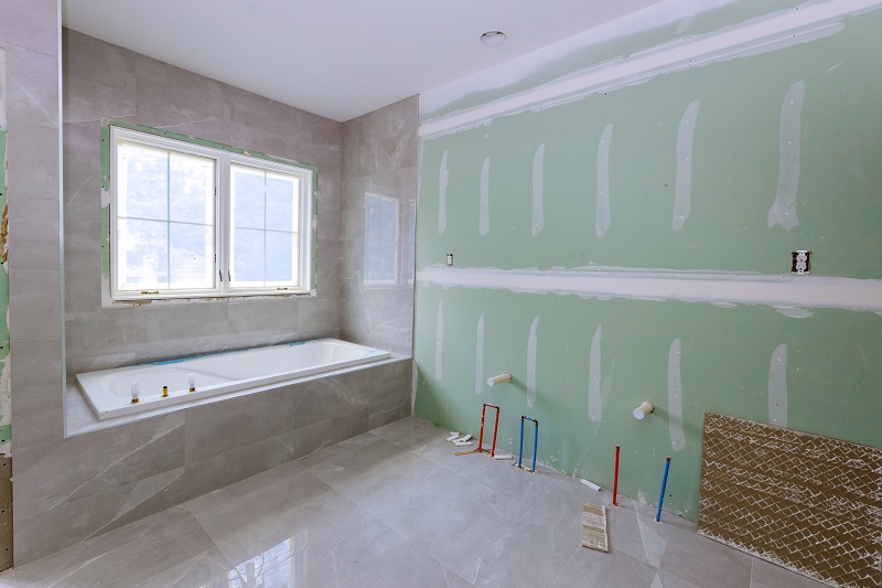 Master bathroom of a custom home being built, with water lines ready to be hooked up