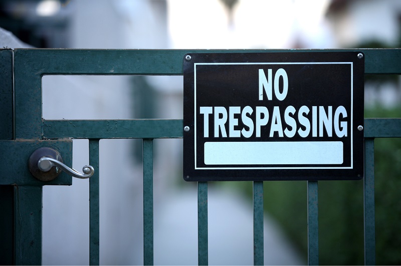 Black residential No Trespassing sign on side gate