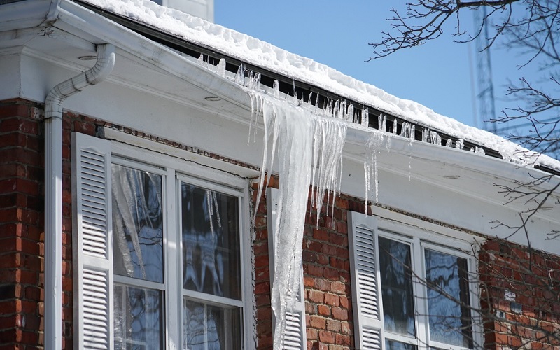 Brick home with damaged rain gutter from ice dam