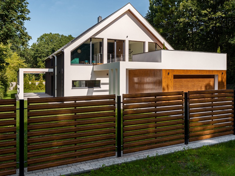 Newly built, modern home with wooden styled fence on secluded lot