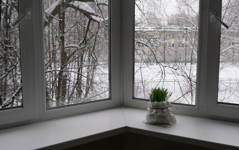 View of winter landscape through four-panel corner window system