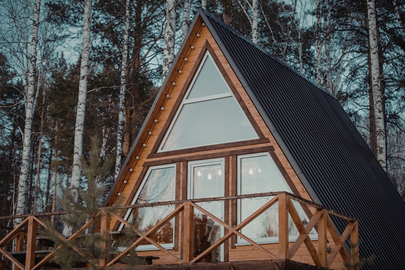Modern cabin with A-Frame metal roof in snow-prone forest