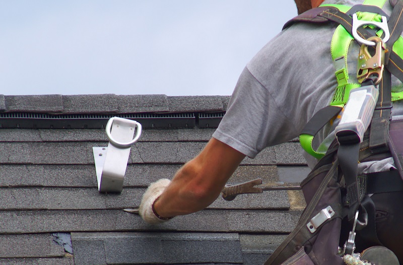 Roofer repairing roof of home