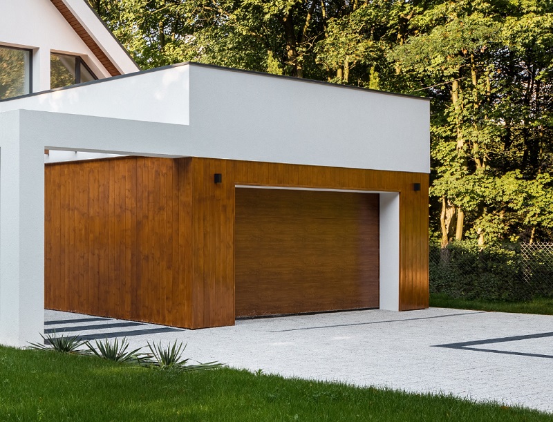 White contemporary home with modern wood cladding around modern garage door