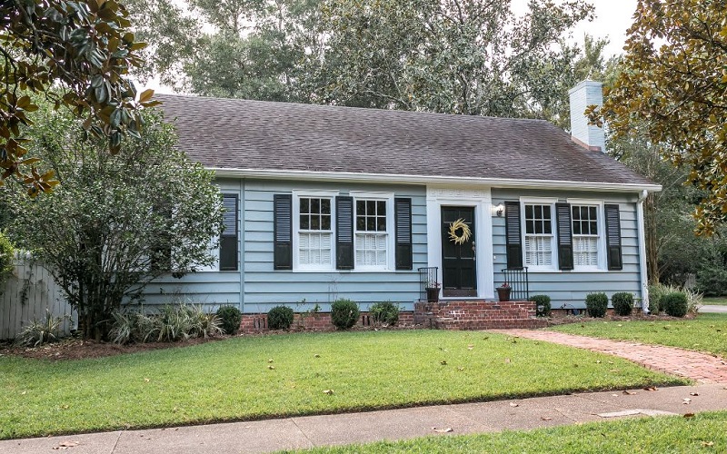 Older blue home with black shutters in good condition
