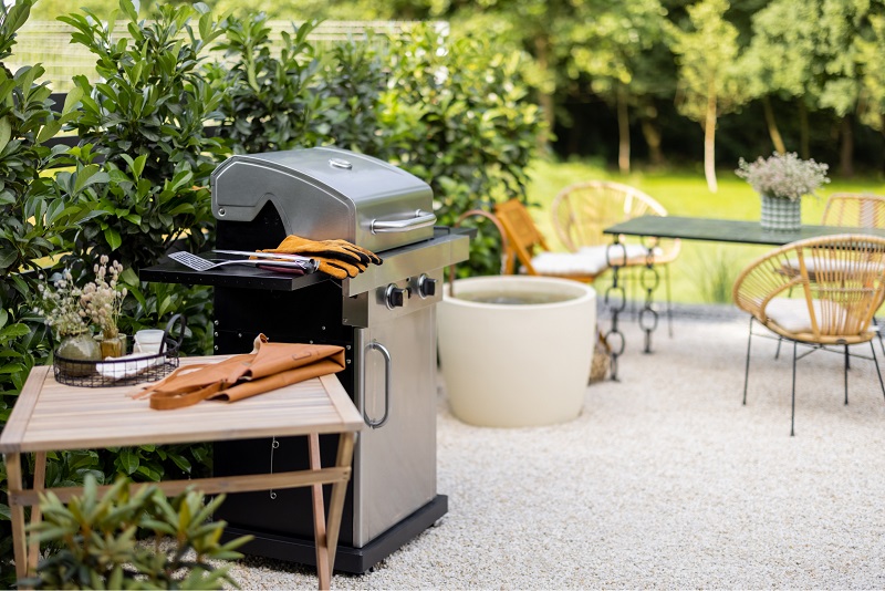 Backyard barbeque area with privacy bushes