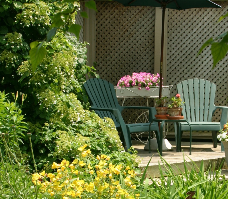 Backyard patio retreat enclosed by wooden trellis screens