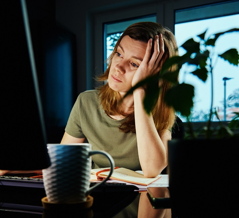 Tired, worried woman working from home