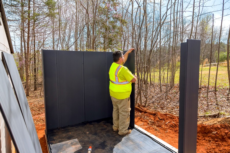 Construction worker assembling a temporary storage shed in the back yard